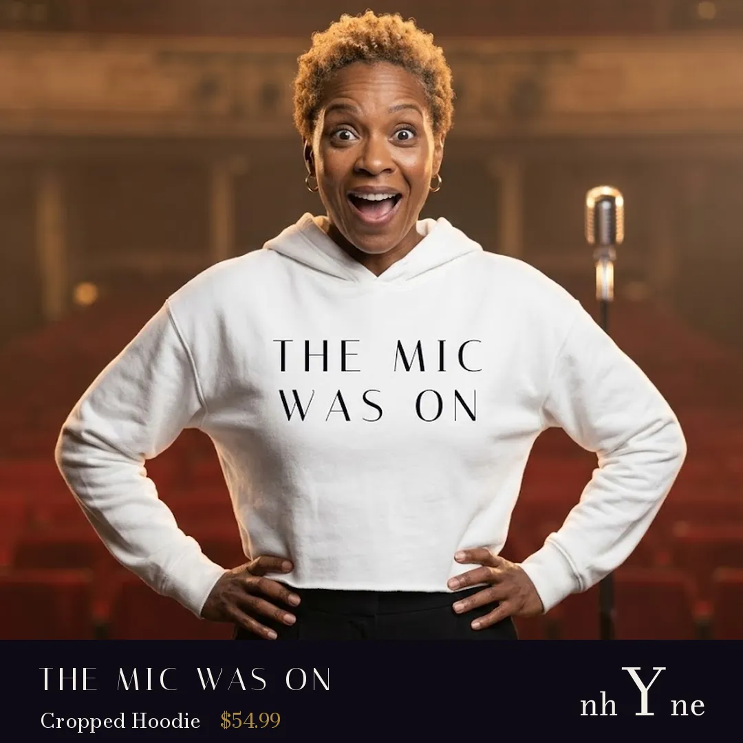 A woman with her hands on her hips in a white cropped THE MIC WAS ON hoodie